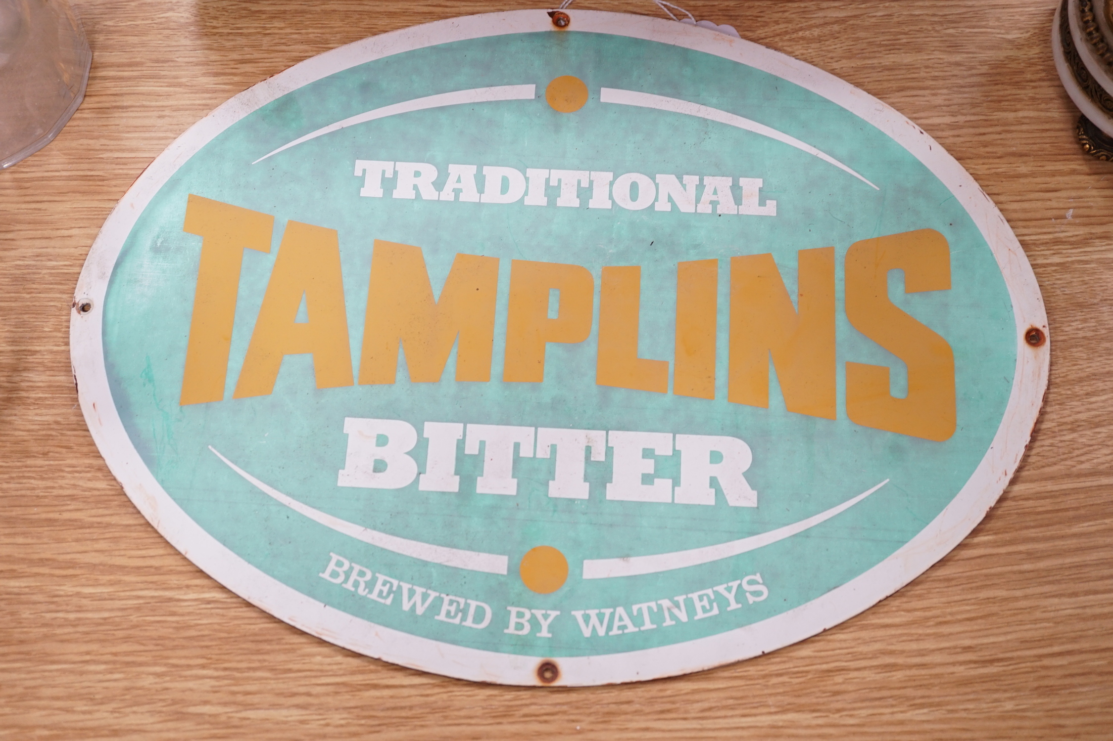 An oval Tamplins bitter advertising sign and a Japanese pillow, the largest 39cm wide